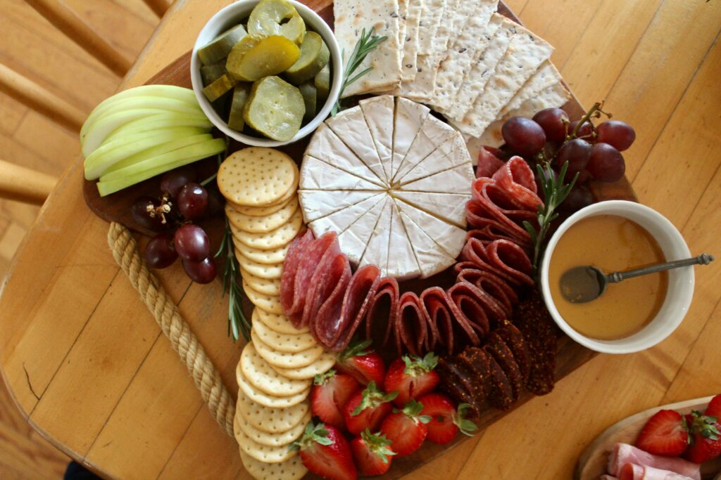 Elegant charcuterie board featuring brie, salami, crackers, fruits, and honey for a perfect gourmet experience.